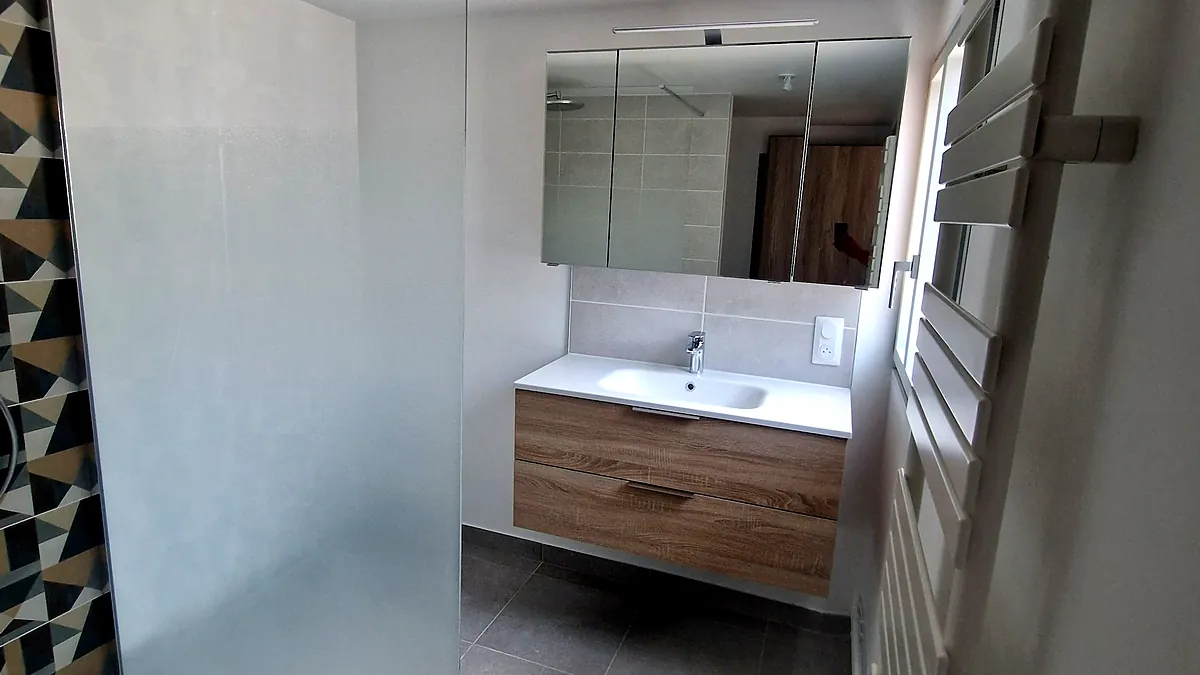 Douche de plain-pied et meuble accessible dans une salle d'eau refaite